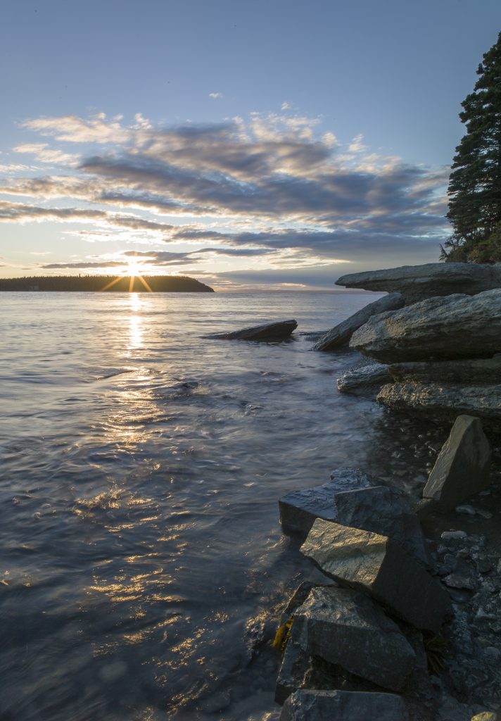 Coucher de soleil sur la forêt boréale et le littoral de calcaire. Réserve de parc national de l’Archipel-de-Mingan / Sunset on the boreal forest and limestone coastline. Mingan Archipelago National Park Reserve